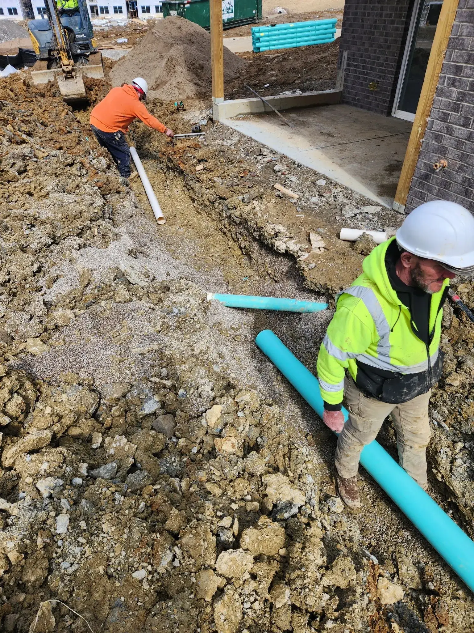 Crew installing storm drainage pipe